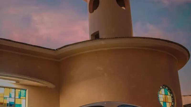 Klassisches dunkles Fahrzeug vor einem historischen Gebäude in der Abenddämmerung